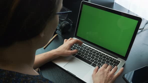 Female hands typing on laptop green screen keyboard and using touchpad.