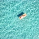 Woman floating on lilo inflatable mattress over blue transparent water surface in summer holiday - VideoHive Item for Sale
