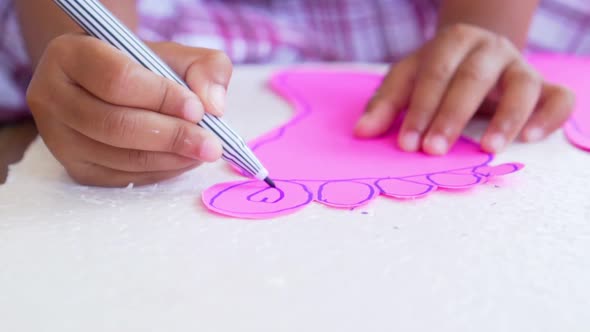 Kid hands using the colored felt pens on paper