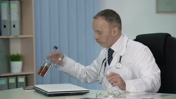 Exhausted Male Doctor Allowing Himself Strong Drink After Hard Working Day