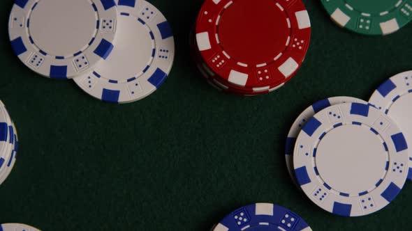 Rotating shot of poker cards and poker chips on a green felt surface - POKER 029