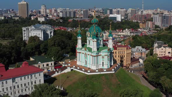 Beautiful flight over St. Andrew's Church in Kiev. Top view of Podol. Many buildings and churches.