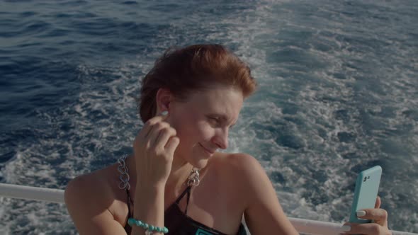 Close Up of 30s Woman in Dress Enjoys Sea Sailing Making Selfie Pictures Sailing on Yacht in the Sea