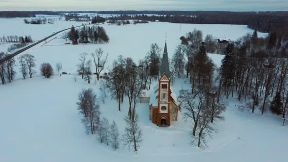 Aerial Top View of the Krimulda Evangelic Lutheran Church in Winter at Sunrise Latvia 4k Video