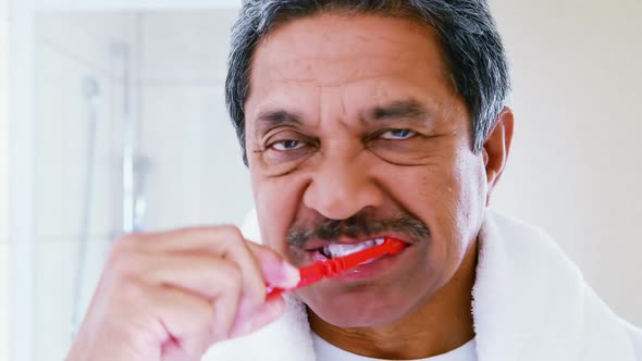 Senior man brushing teeth in bathroom 4k