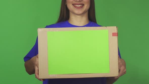 Cropped Shot of a Delivery Woman Smiling Holding Carboard Box with Copyspace