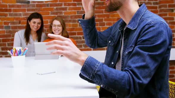 Male executive using virtual reality headset at desk