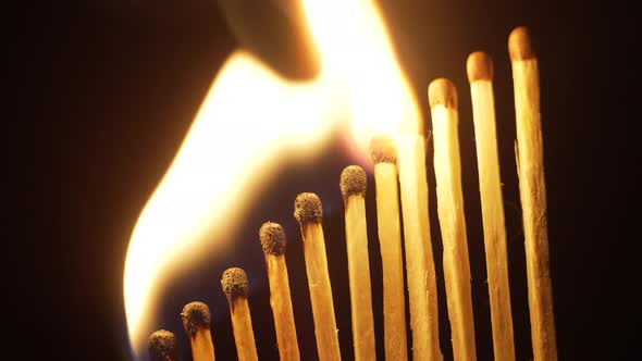 An Even Row of Matches Lined Up By a Ladder Alternately Lights Up on a Dark Background