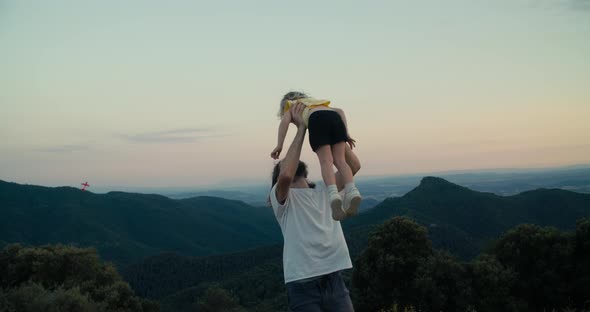 Father Tosses His Daughter Aver Himself on Mountain Trip Adventure at Landscape