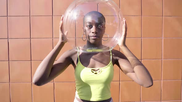 Slow motion shot of young woman holding glass container over head