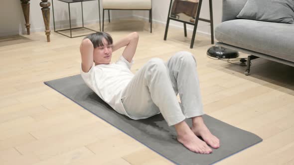 Young Asian Man Doing Workout on Yoga Mat at Home