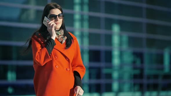 Beautiful Girl in a Red Coat Talking on the Phone