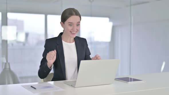 Ambitious Young Businesswoman Celebrating Success in Office 