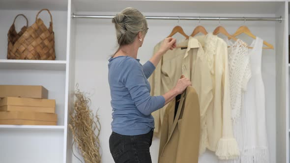 Elderly Woman During Chooses Clothes at Home