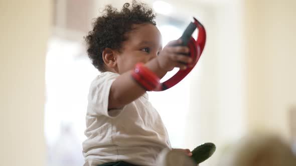 Cute Little Boy Passing Headphones to Unrecognizable Father Sitting in Kitchen with Cucumber in Hand