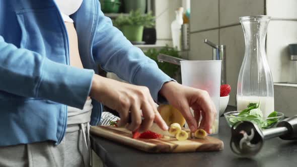Woman cutting fresh fruit in the kitchen