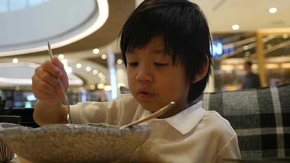 Cute Asian Child Eating Japanese Noodles In A Restaurant Slow Motion