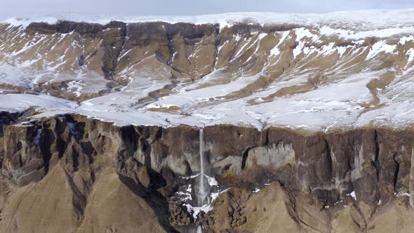 Small and Beautiful Waterfall on a Snowcapped Ledge in the Winter