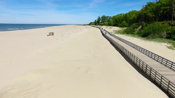 Aerial view of the long wooden promenade on a beach of Yantarny resort town, Russia