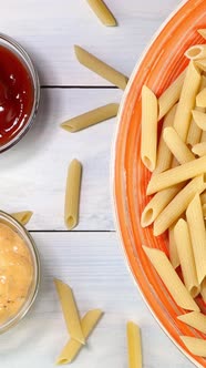 Uncooked Raw Italian Penne Pasta Rotating Slowly on Turntable in Dish