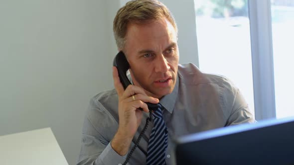 Businessman talking on telephone in office 4k
