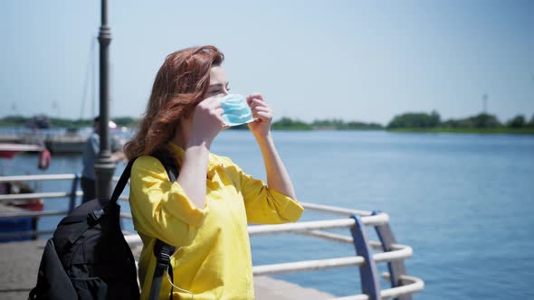 Lifestyle Coronavirus, Cheerful Female Traveler Enjoys Outdoor and Wears a Medical Mask To Protect