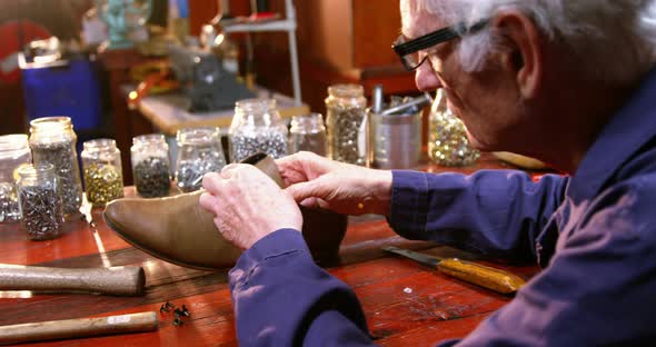 Shoemaker examining a shoe