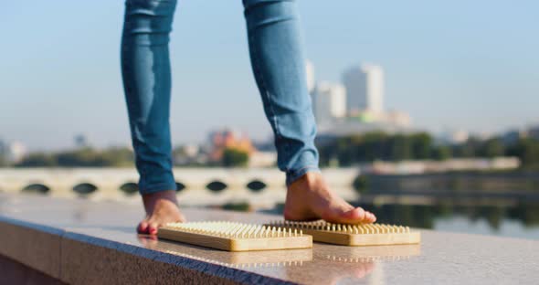 Women's Feet Stand on Sadhu Boards on an Urban Background