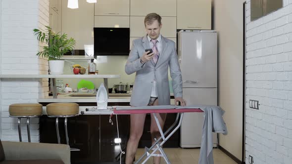 Handsome Businessman in Tie Ironing Pants at Home. Preparing for Meeting