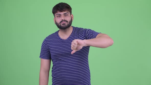 Angry Young Overweight Bearded Indian Man Giving Thumbs Down