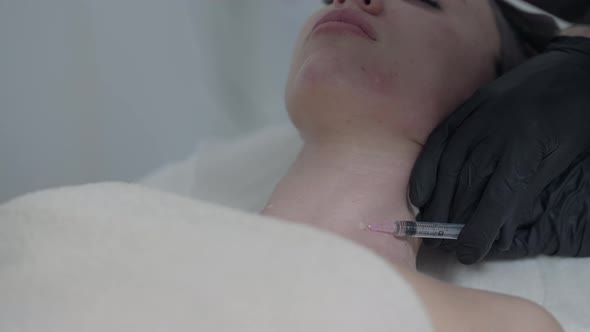 Closeup Beauty Injection with Syringe in Slim Female Caucasian Neck