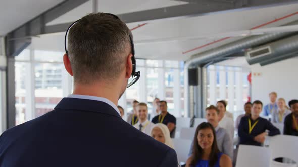 Male speaker with headset microphone addressing the audience at a business seminar