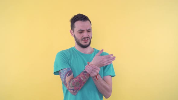 Sporty Young Man Holding His Wrist and Suffering From Injury