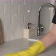A Housewife in Yellow Rubber Gloves Washes and Wipes a Marble Kitchen Countertop - VideoHive Item for Sale