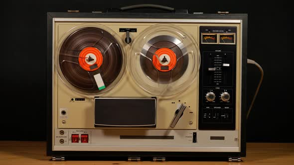 Vintage Reel to Reel tape recorder playing music close up of reel