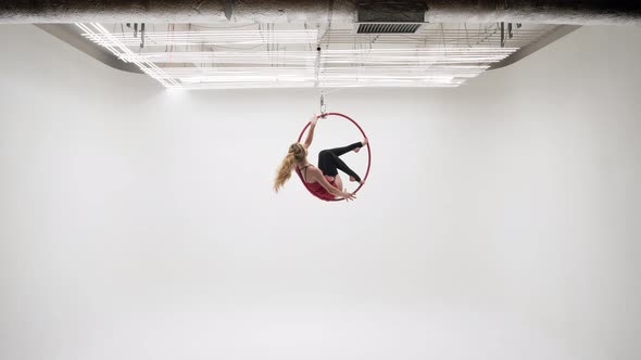 Girl Gymnast Performs Longitudinal Twine In The Aerial Ring