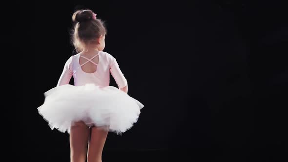 Little Girl Ballerina Caucasian Appearance in a Pink Tutu Dances on Stage