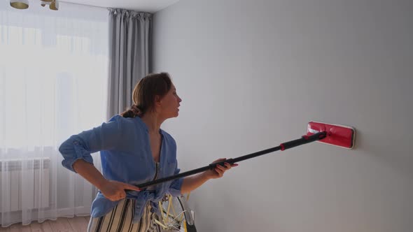 Cleaning Company Worker Washes the Wall