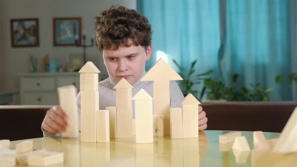 boy creatively builds a building out of bricks. Board educational game.