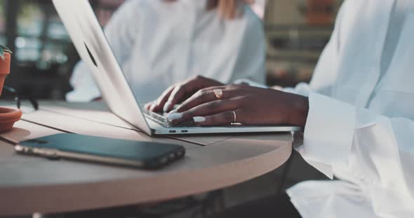 Woman types on laptop while talking business