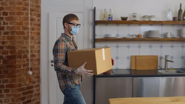 Guy in Protective Wear Holding Delivery Box at Home