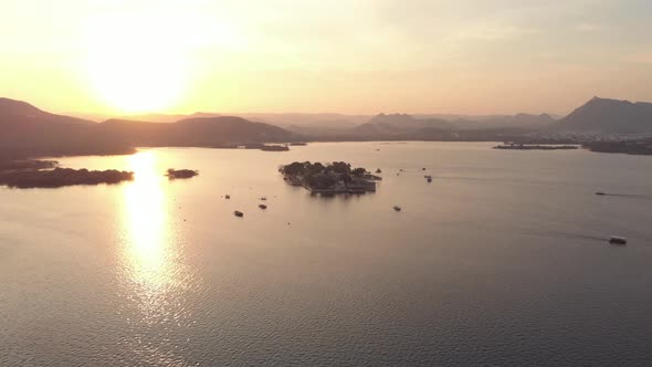 Lake Pichola golden view during sunset with Taj Lake Palace in the center, in Udaipur, India