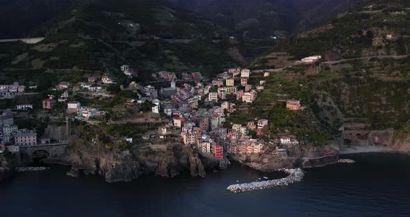 Aerial arc of Riomaggiore colorful houses on terraced hillside, Italy