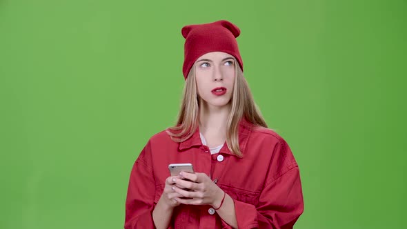 Girl Is Holding a Phone and Printing a Message. Green Screen