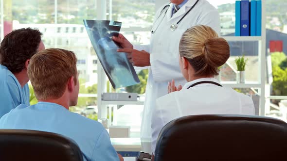 Doctors showong Xray to his colleagues