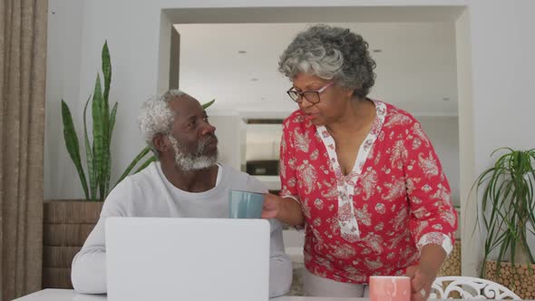 A senior african american couple spending time together at home using a laptop. social distancing in