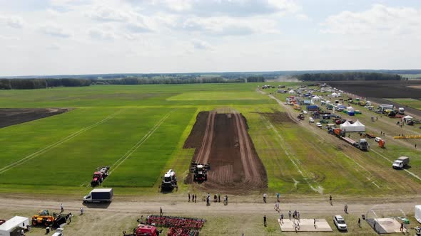 Red Harvester Drives Across Field and Plows Earth