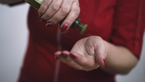 Woman Massage Therapist Applies Oil Onto Palms in Clinic