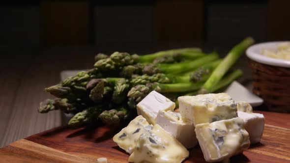 Closeup Panorama of Garlic and Spears of Green Peeled Asparagus on Wooden Board