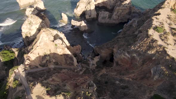 Boardwalk with steep steps from top cliff lead down to rocky sheltered  beach,  Lagos, Algarve